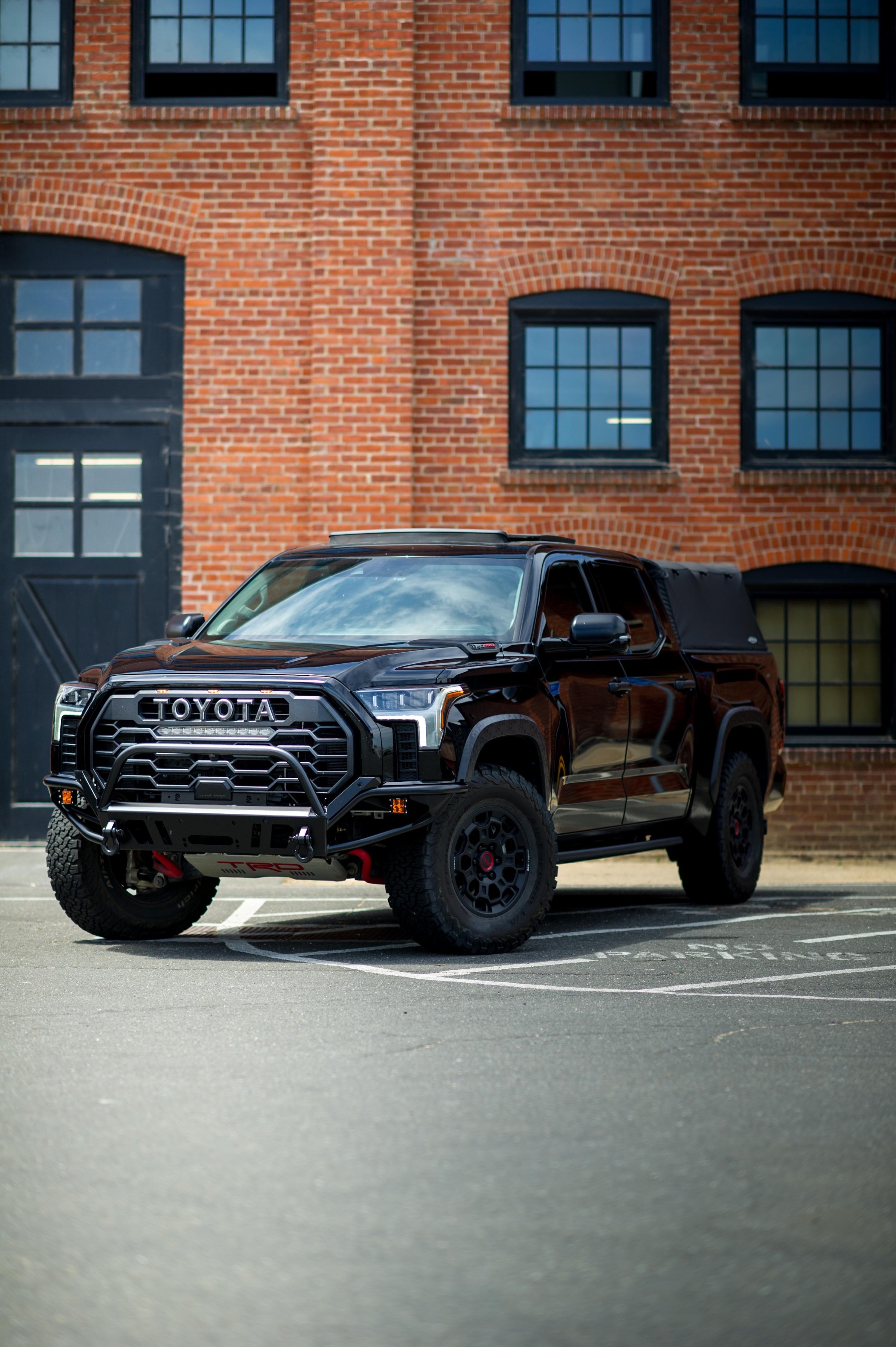 Toyota Tundra fitted with a heavy-duty offroad bumper, engineered for tough terrain and outdoor adventures, showcased in a wilderness setting, emphasizing durability and offroad performance.